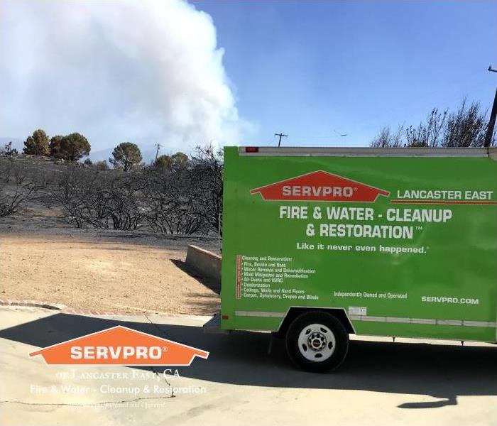 SERVPRO truck with wildfire behind
