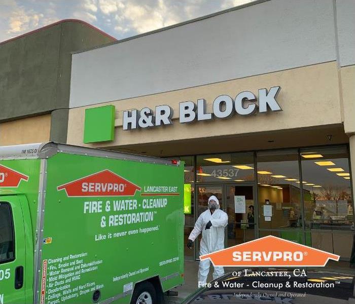 commercial building with green servpro truck parked in front